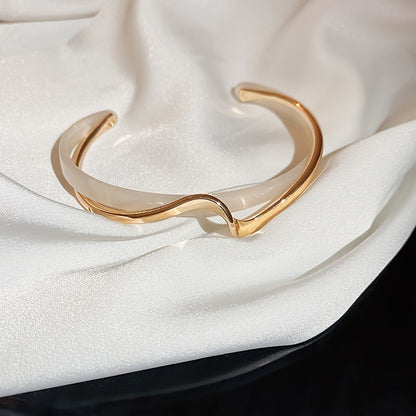 Wave-shaped cuff bangle with faux pearl inlay, featuring a minimalist style in 18K gold plating, ideal for women's jewelry collection