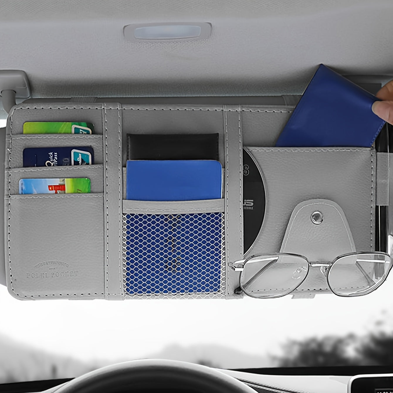 Stylish visor organizer with compartments for glasses, CDs, smartphones, wallets, and cards. Durable and compact design.