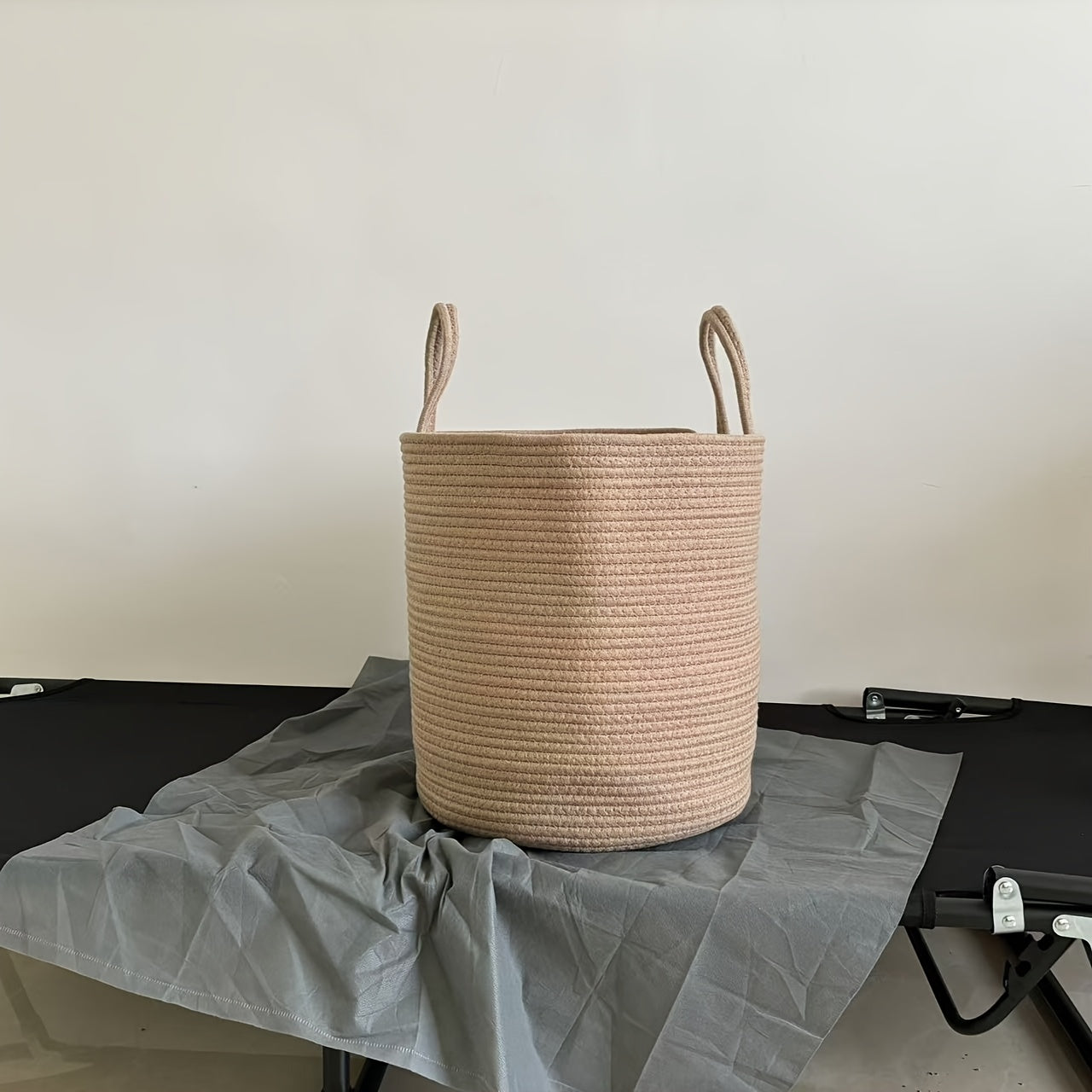 Large capacity rustic cotton rope woven laundry basket with a modern style, perfect for organizing clothes in your home. This round-shaped basket has handles for easy transportation and is ideal for use in the laundry room. No lining included.