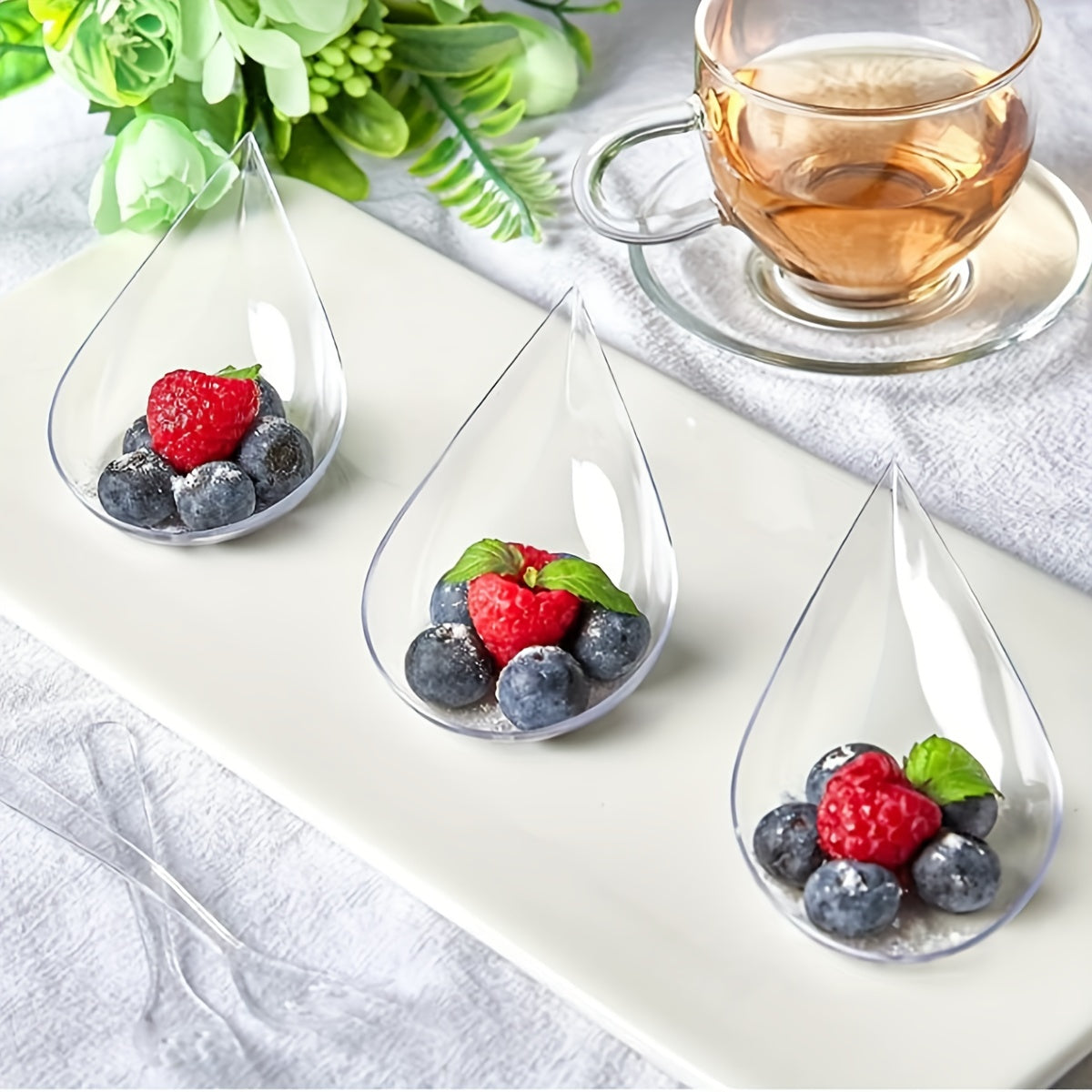 A set of 50 or 100 pieces of 10.16 cm mini appetizer plates and tasting forks, made of clear plastic. Ideal for serving appetizers, banquets, dinners, desserts, and tasting spoons in a teardrop shape.