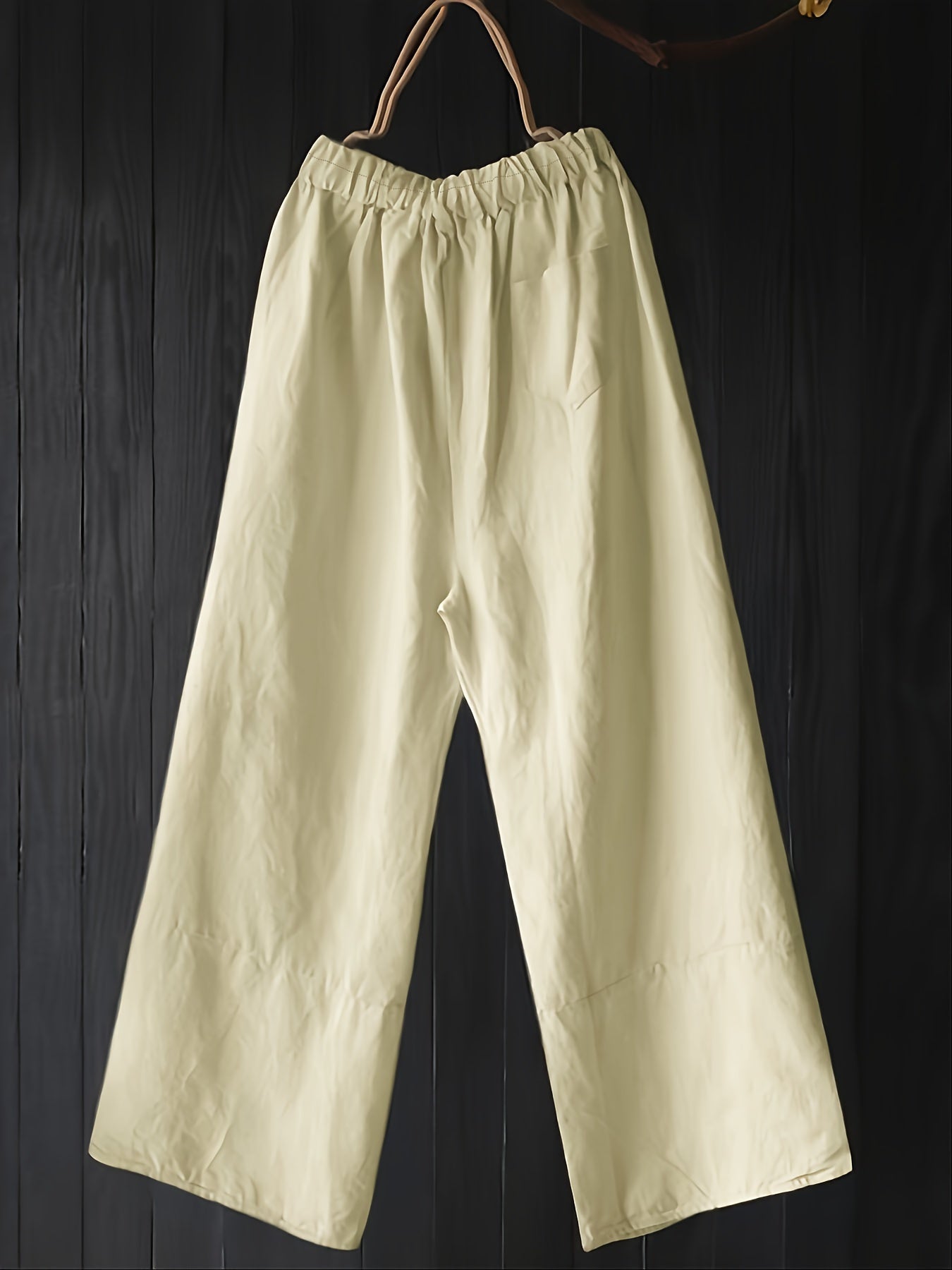 Green high-waist wide leg pants with unique button details, loose fit, pleated design, ideal for fall outings.