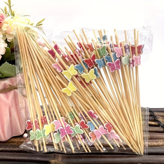 Colorful bamboo cocktail picks with elegant butterfly design in assorted colors - disposable fruit skewers for parties, holidays, and table decorations. Available in red, yellow, blue, and purple.