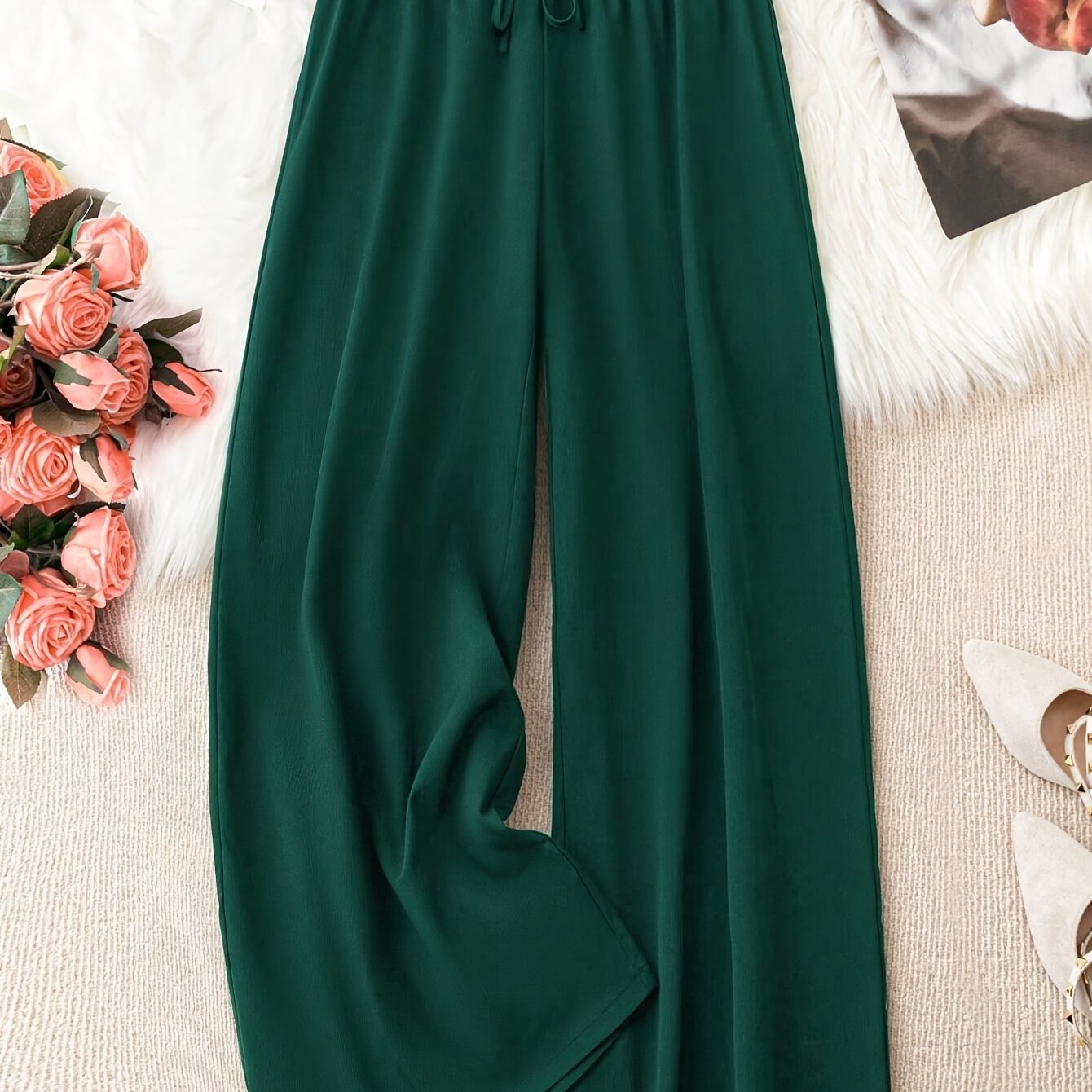 Flowy green polyester wide-leg pants with a tie waist, high-rise fit, and smooth fabric. Suitable for casual or office wear in spring/summer/fall. Machine washable.