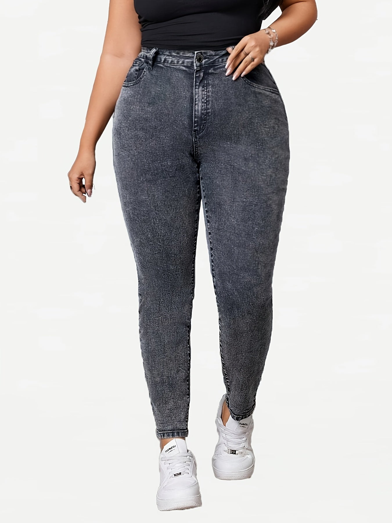 Plus-size high-waisted skinny jeans in heather gray washed denim with distressed detail. Made of 70% cotton, 27.6% polyester, and 2.4% spandex blend. Features elegant button fly, long