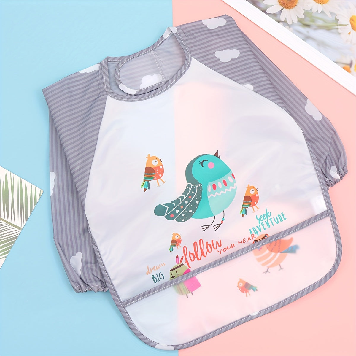 Easily cleanable reverse wear cartoon bib with waterproof long sleeves, suitable for home and travel.