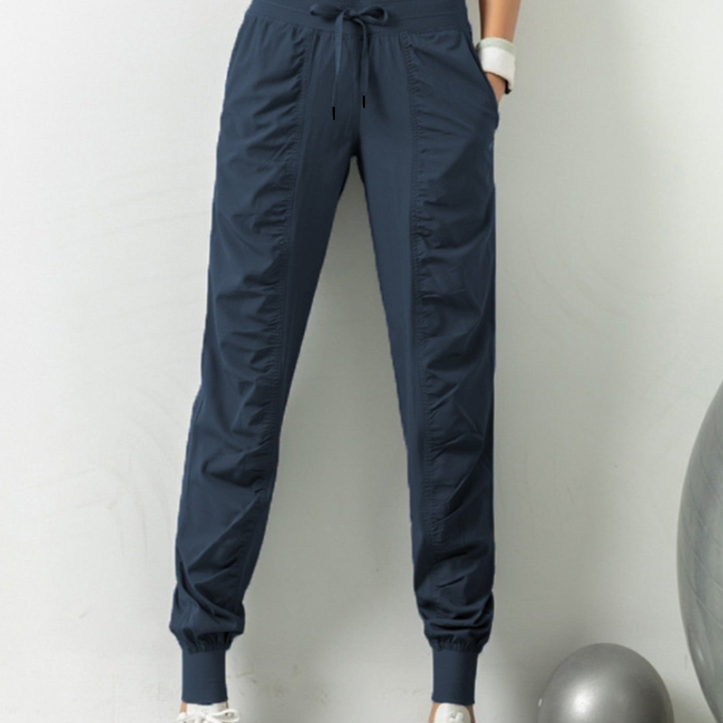 Women's solid color sports pants with drawstring waist, quick drying material, and side pockets for casual comfort.