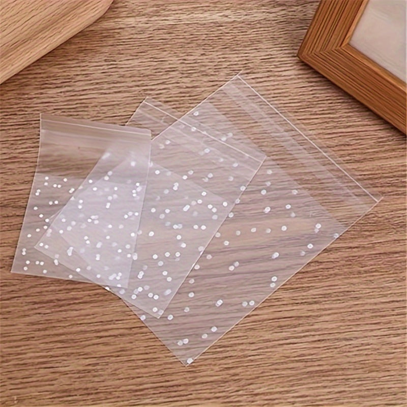 100 pieces of frosted self-adhesive bags with white dots designed for wrapping cakes, chocolates, candies, snacks, and other treats. These clear plastic treat bags can also be used as goodie bags, goody bags, and gift pouches for party supplies.