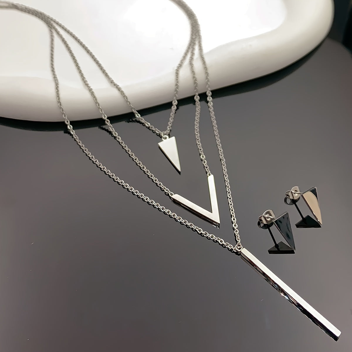 Three pieces of Stainless Steel Long Strip V-shaped Geometric Pendant with a Multi-layer Necklace and Triangle Earrings. Perfect as a Birthday or Holiday Gift, Clothing Decoration, or Party Accessories.