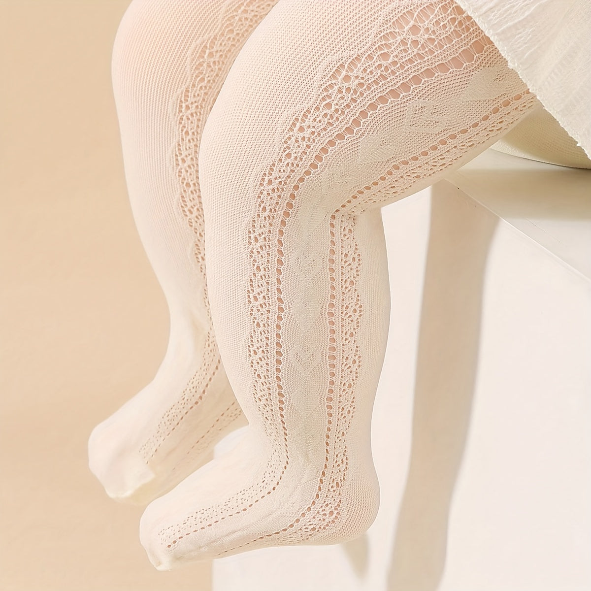 Two pairs of girls' white and beige princess-style tights with heart pattern and breathable comfort.