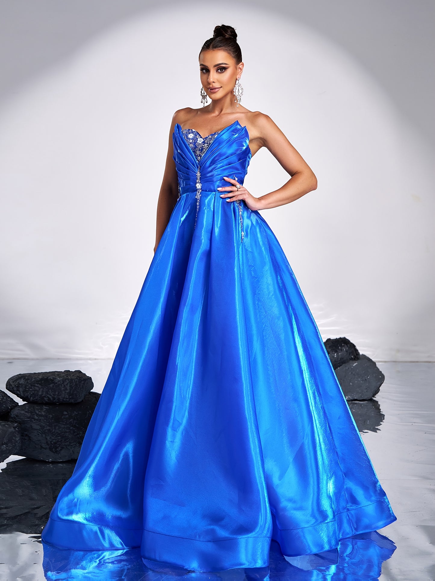 Elegant royal blue satin tube dress with rhinestone detailing and backless design, perfect for parties and formal events. Off-shoulder gown with flowing skirt and structured silhouette.