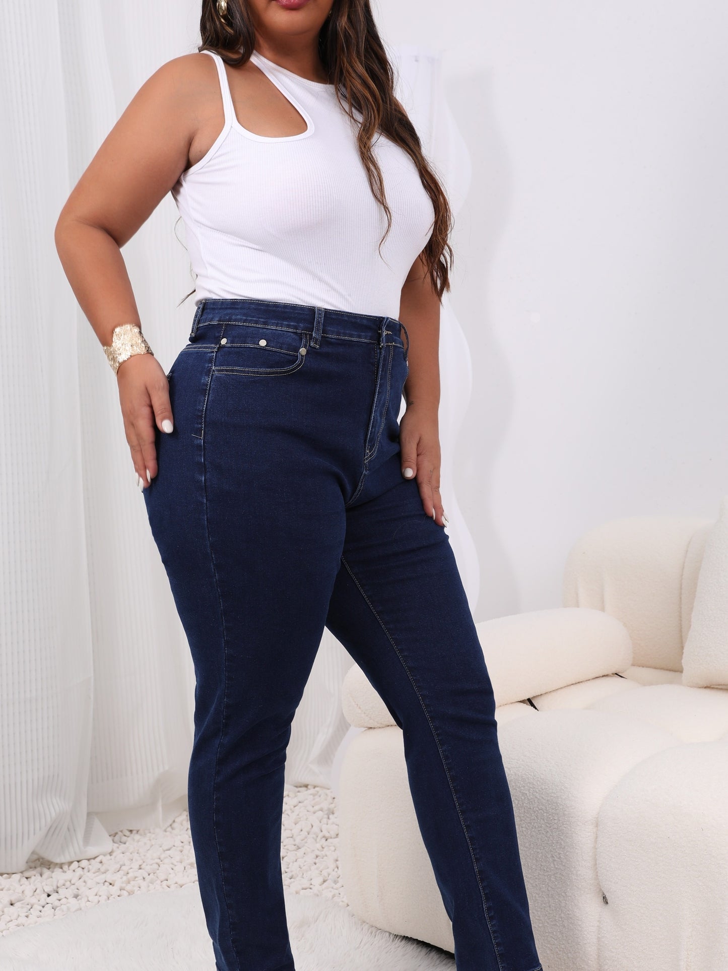 Women's plus size high-rise jeans with solid color and button fly, offering a comfortable stretch fit.