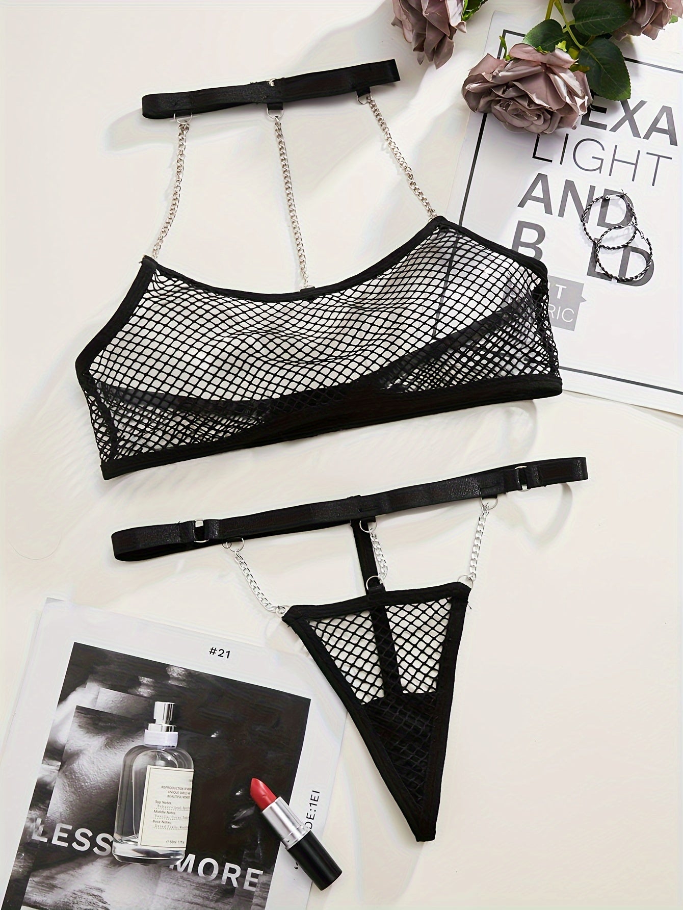 Black mesh lingerie set with metal chain straps, perfect for a seductive night in bed