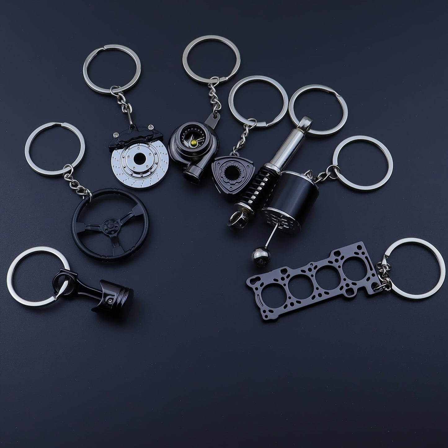 Keychains for creative car modifications, including piston, brake disc, gear, turbocharger, small rotor, shock absorber, engine blade, and steering wheel designs. Perfect for car enthusiasts and as a unique gift.