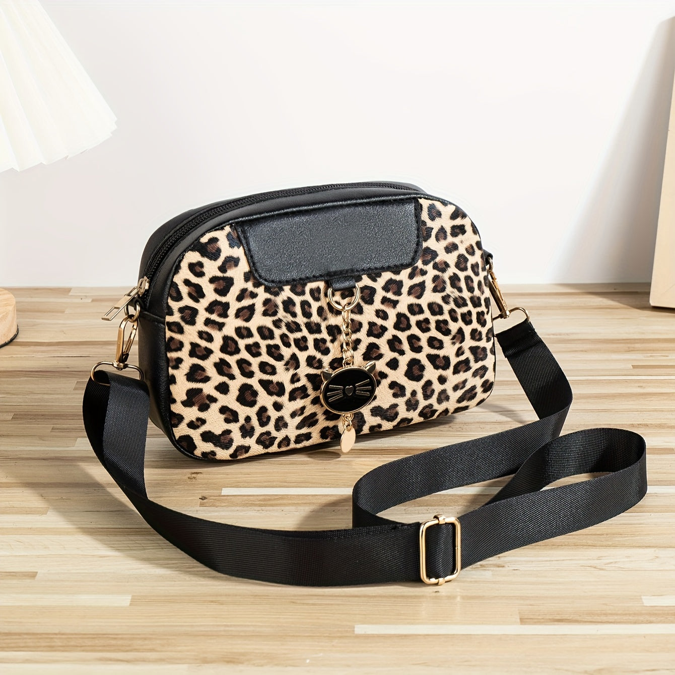 Chic leopard print crossbody bag with adjustable strap, cat charm, zip closure, and polyester lining - ideal for work, outings, and daily commutes.