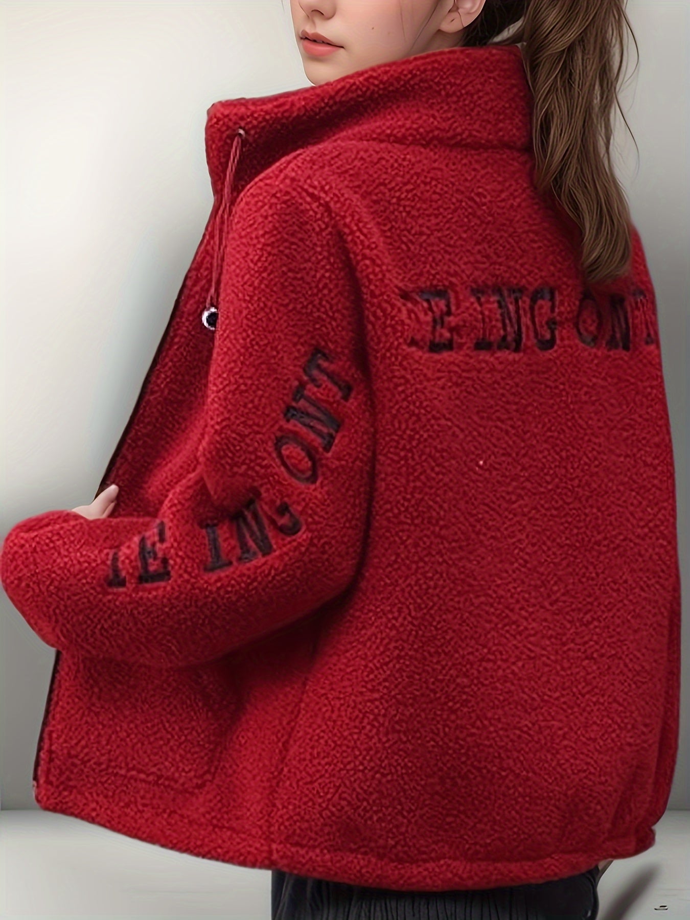 Cozy fleece-like jacket for women with embroidered letters in warm red velvet, perfect for all seasons. Cute and casual with a stand collar, long sleeves, and fleecelike texture.