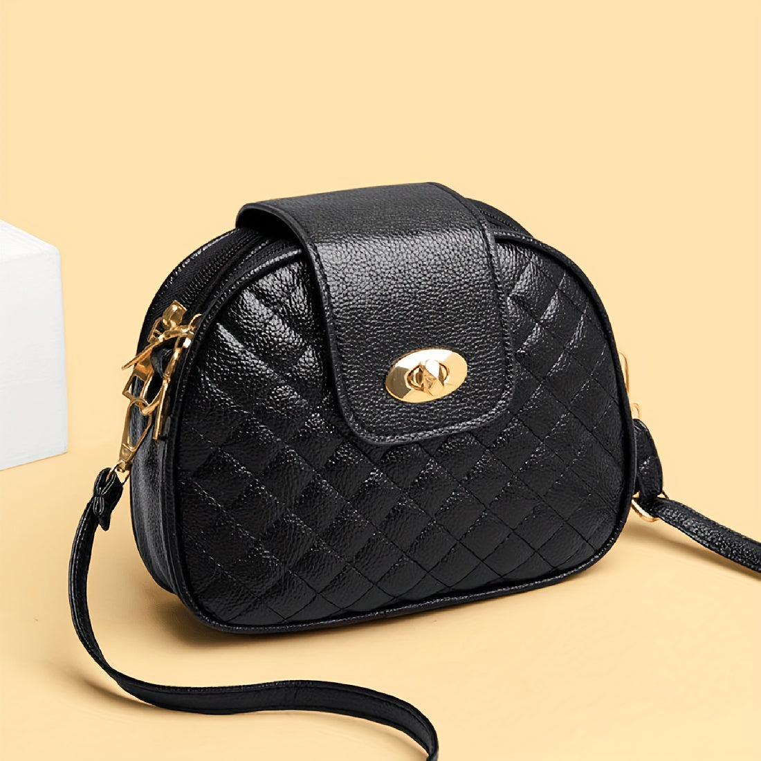 Women's faux leather crossbody bag with argyle quilted design, turn-lock closure, triple compartments, polyester lining, and adjustable strap for any occasion.