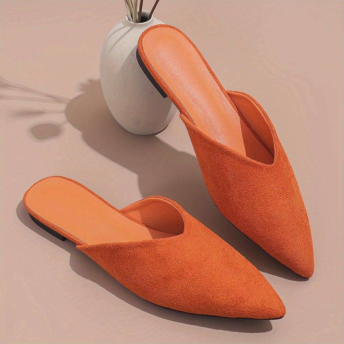 Stylish orange flat mules for women in plus sizes with pointed toe and slip-on design, perfect for casual wear.