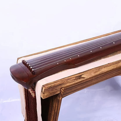 NUNUGGS Traditional Chinese Guqin made of solid paulownia wood with elegant black finish and golden tone tuning pins. Suitable for beginners, photo props, and antique interpretation.