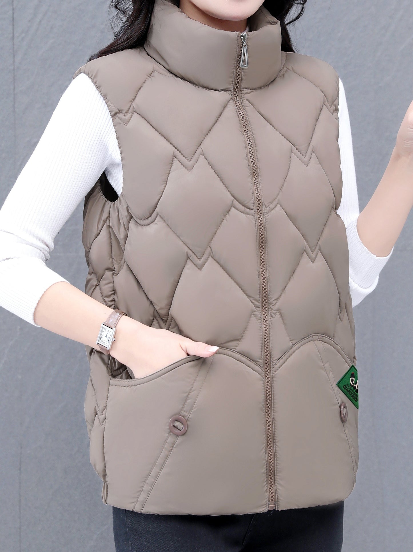 Women's polyester vest with quilted stand collar, zipper closure, pleated hem, and loose fit. Ideal for fall/winter casual wear with a Middle Eastern style.