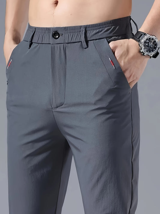 Men's slim fit casual pants made of breathable nylon fabric with pockets and embroidery. Suitable for outdoor and daily wear in a solid color basic style. Features zippered waist for