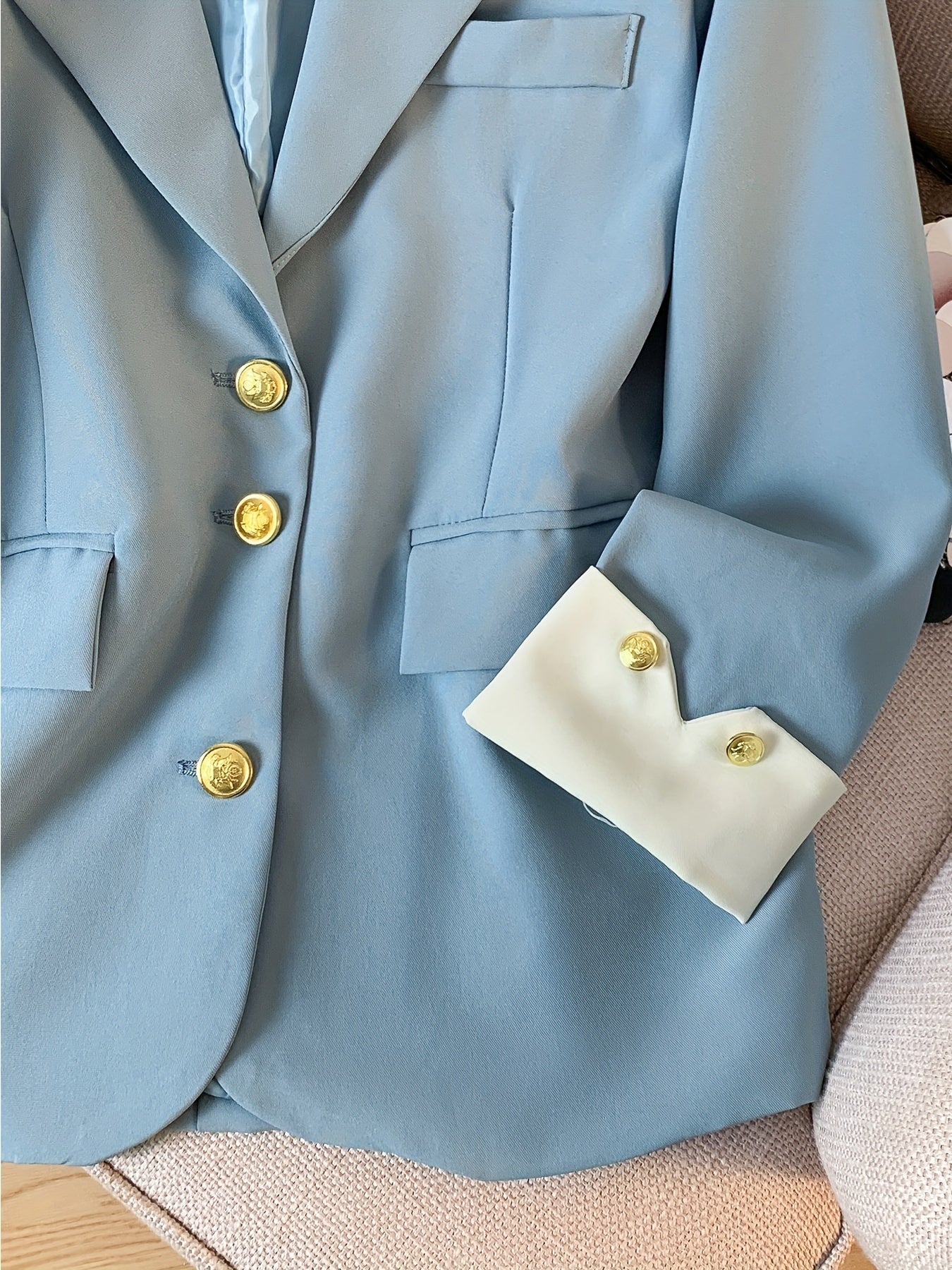 Stylish light blue blazer with golden button details for women, ideal for work in spring and fall.