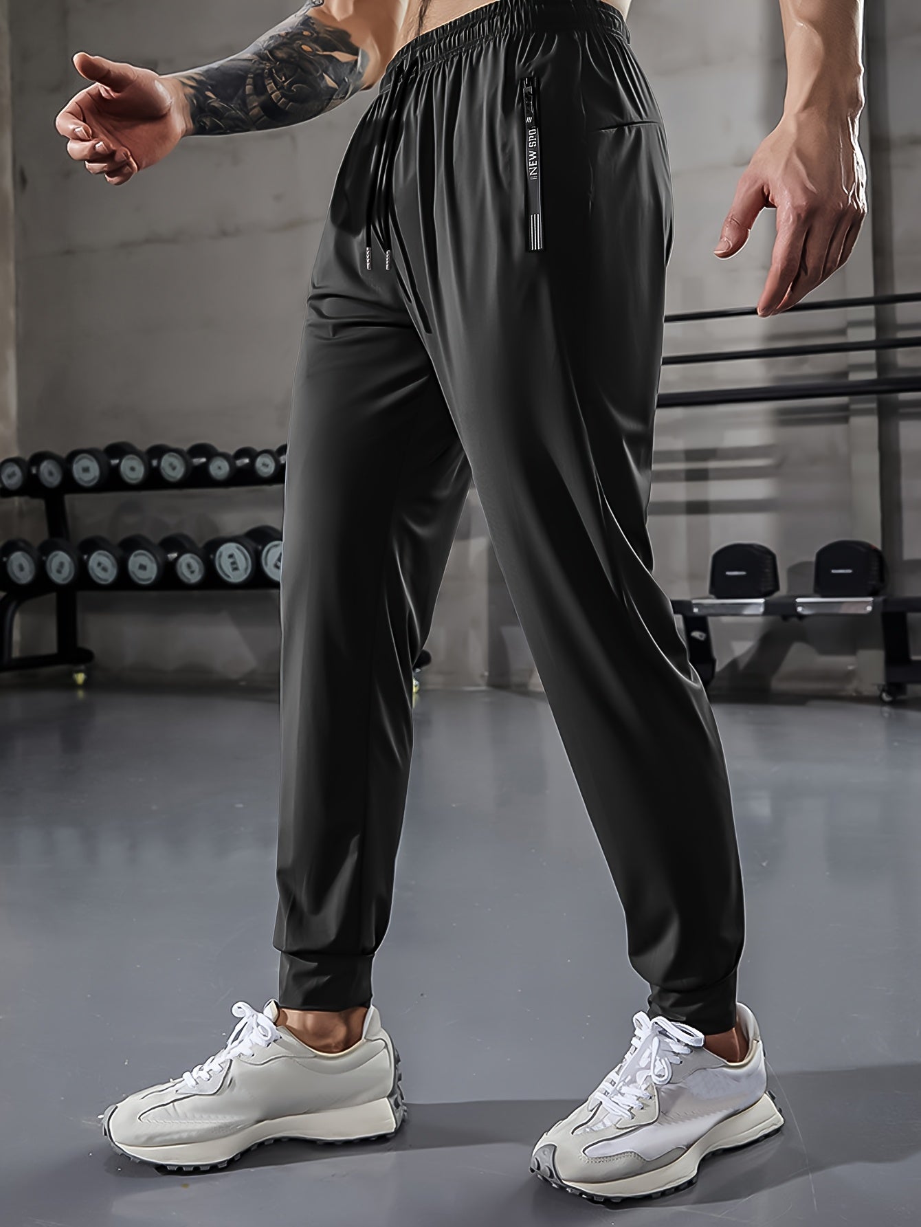 Men's athletic stretch pants with adjustable drawstring waist, zippered pockets, solid color, quick-dry material, ideal for fitness and running.