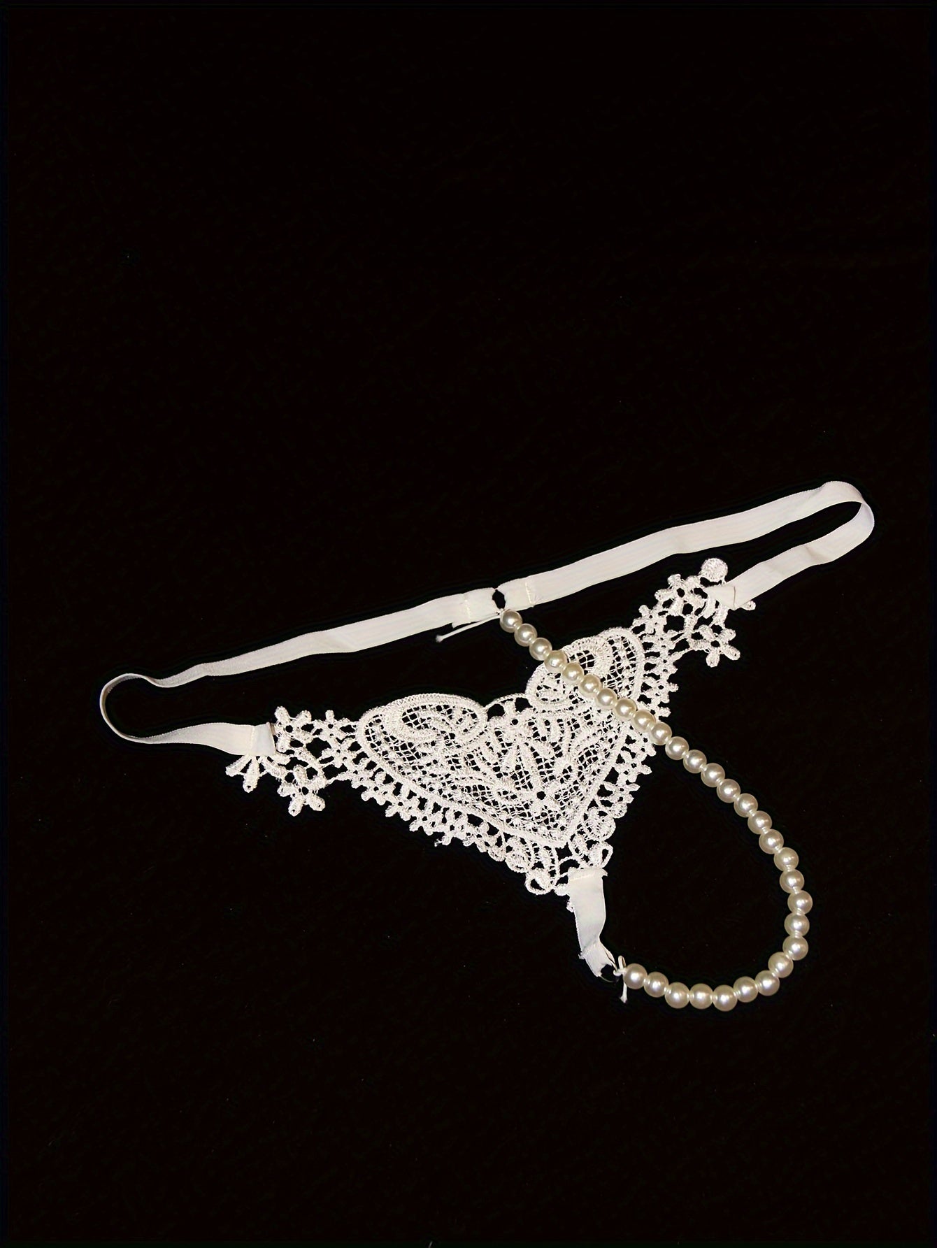 Low-rise thong with pearl embellishments and hollow out design. Breathable polyester, hand washable. Ideal for adults.