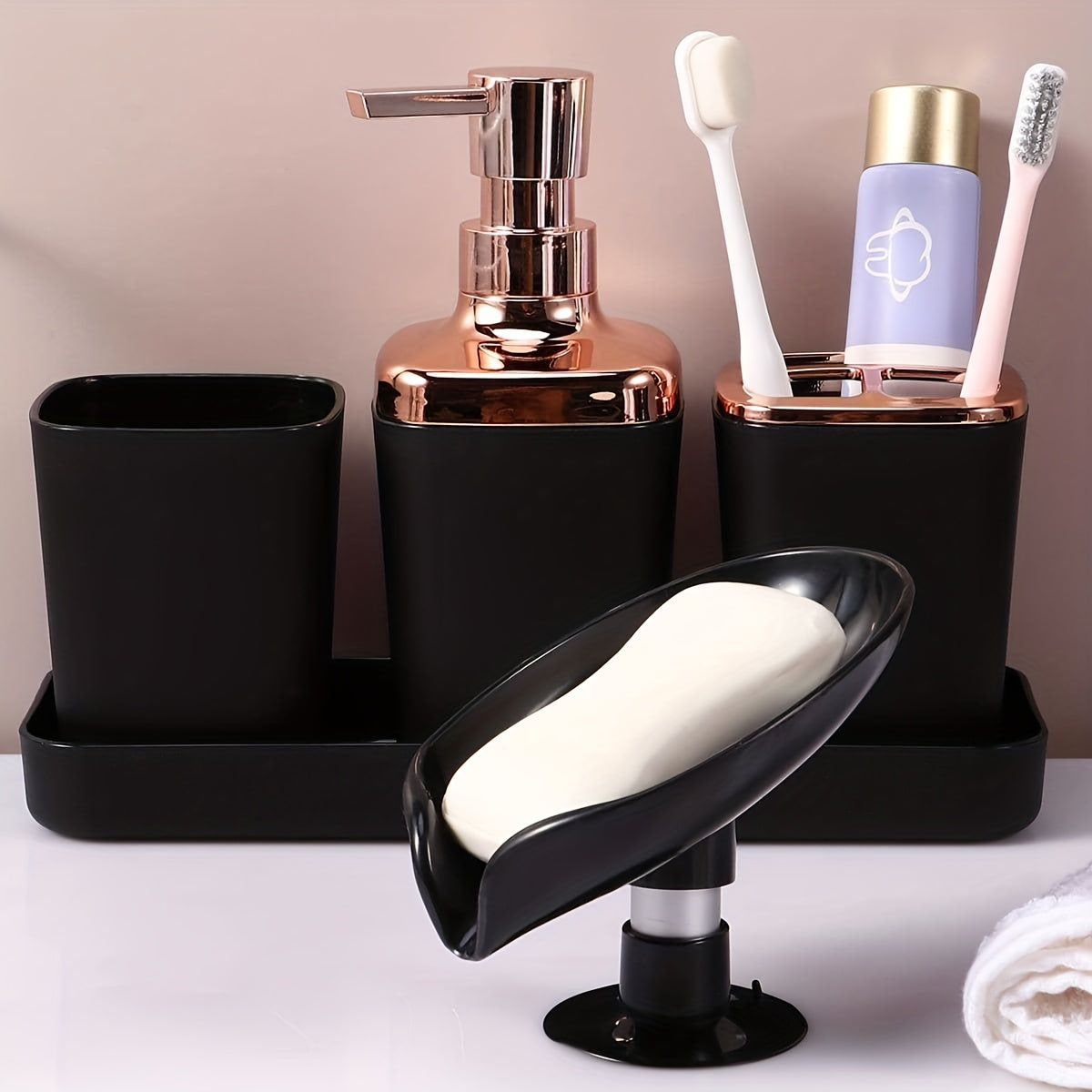 Stylish 5-piece black bathroom set with golden accents, includes lotion dispenser, toothbrush holder, cup, soap dish, and tray made of sleek plastic for elegant home decor.