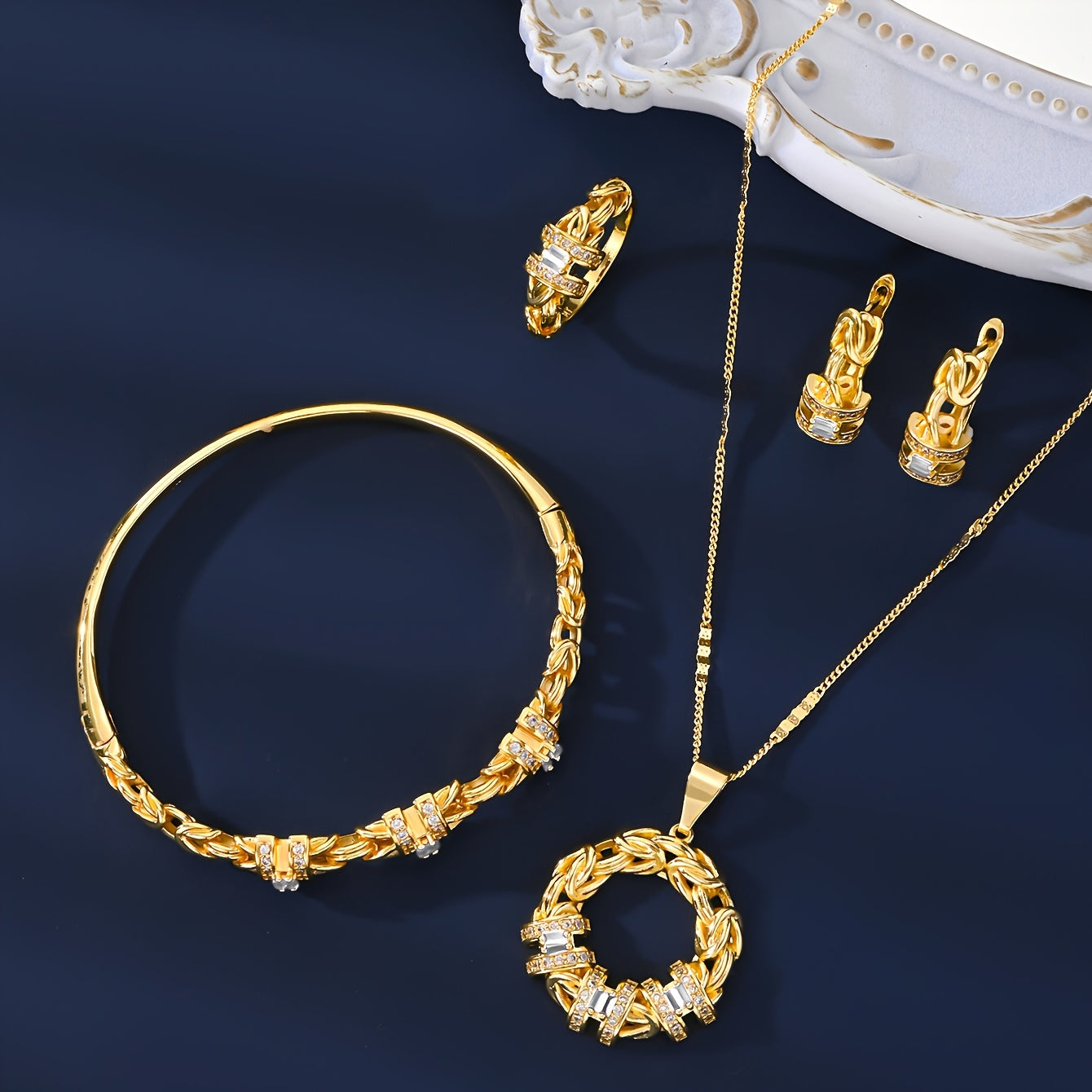 Luxurious Dubai-inspired jewelry set crafted with simple brass material and 18k Gold Plating, adorned with Zirconia stones. This elegant 5-piece set includes a necklace, earrings, bracelet, and ring, perfect for daily wear or as a special gift. The Retro