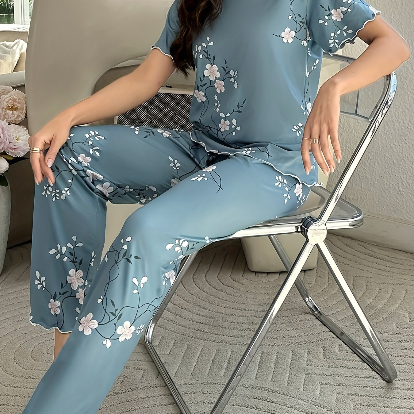 Women's sleepwear set with floral print, frill trim, short sleeve top, and elastic pants.