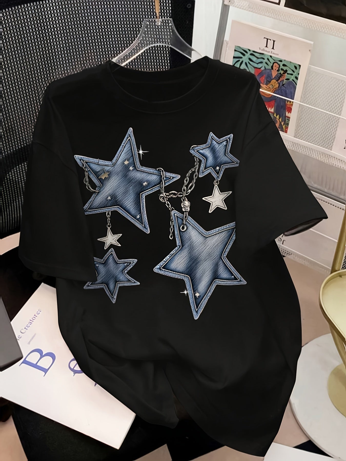 Women's graphic tee with sun, moon, and stars design, short sleeves, crew neck, stretchy polyester blend, machine washable.