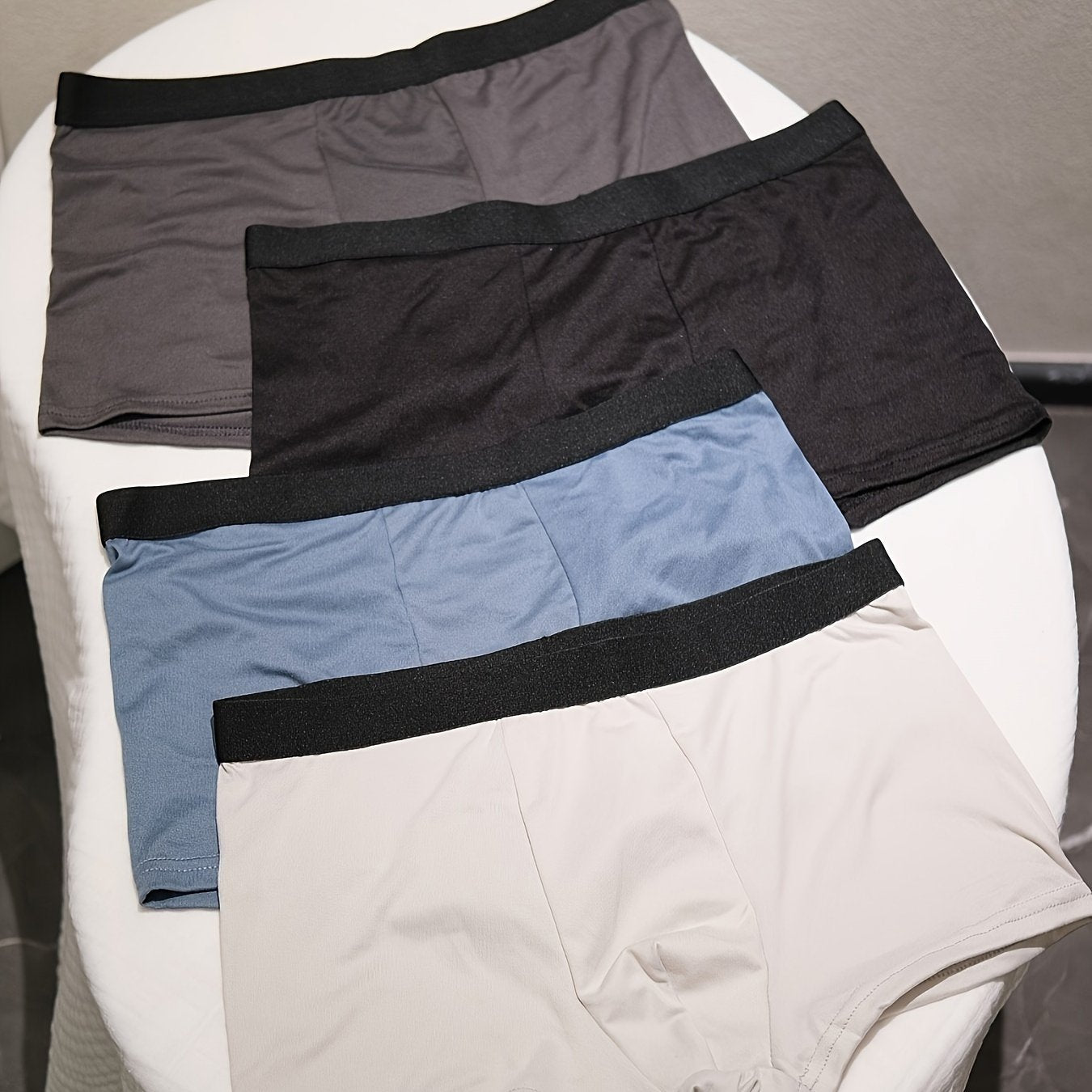 4-pack of men's breathable boxer briefs made from a comfortable, stretchy polyester-spandex blend. Solid color shorts with elastic waistband that are non-see-through and made from