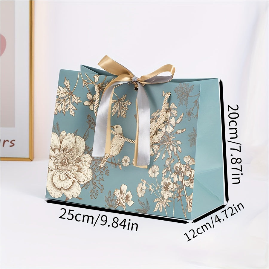 Floral paper gift bag with golden ribbon, teal background, brown, white & gray flowers, suitable for birthdays, weddings, Mother's Day, and special occasions. Features drawstring closure.