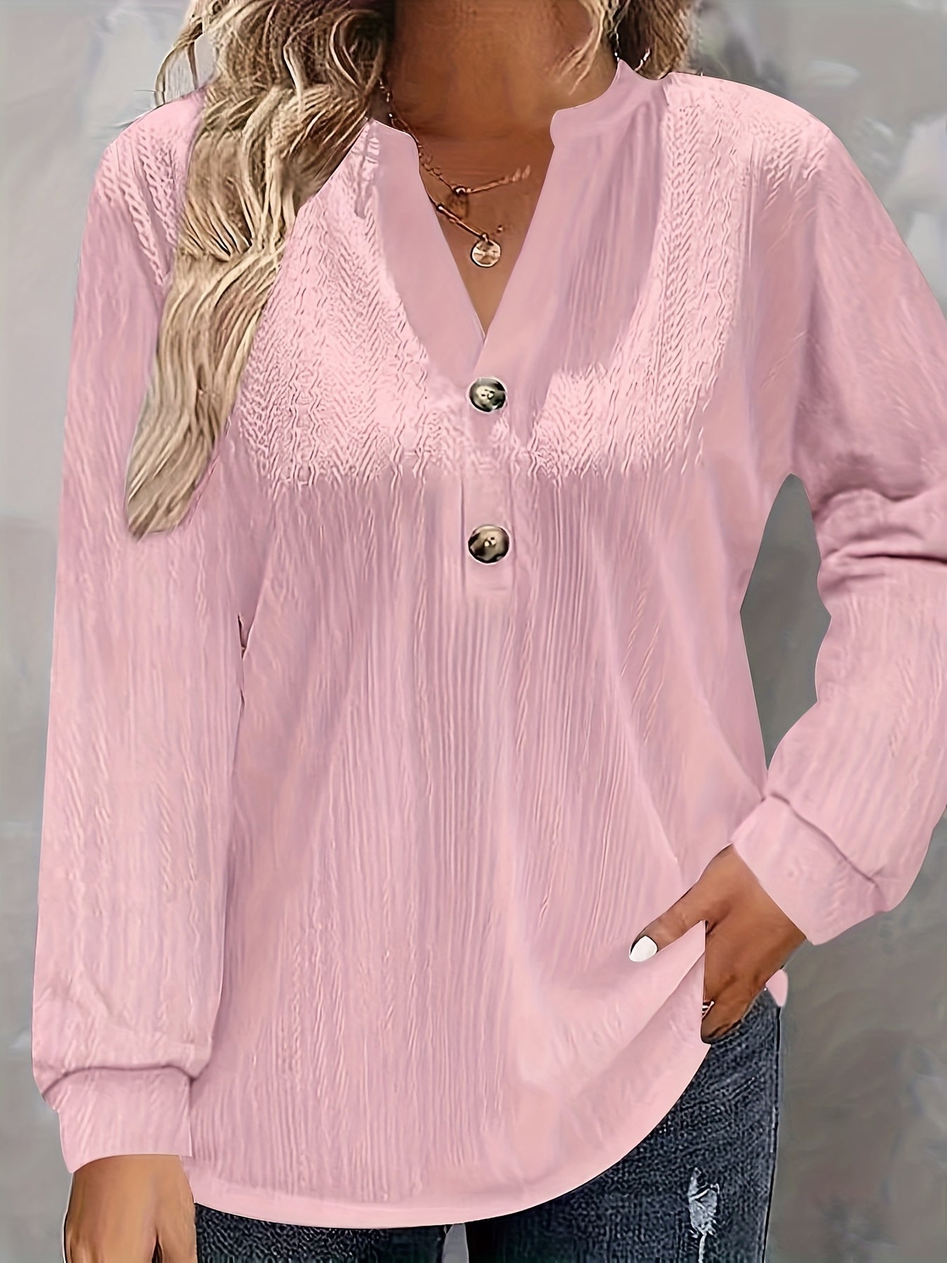 Light pink V-neck shirt with long sleeves and button detail, perfect for fall/winter in soft polyester blend.