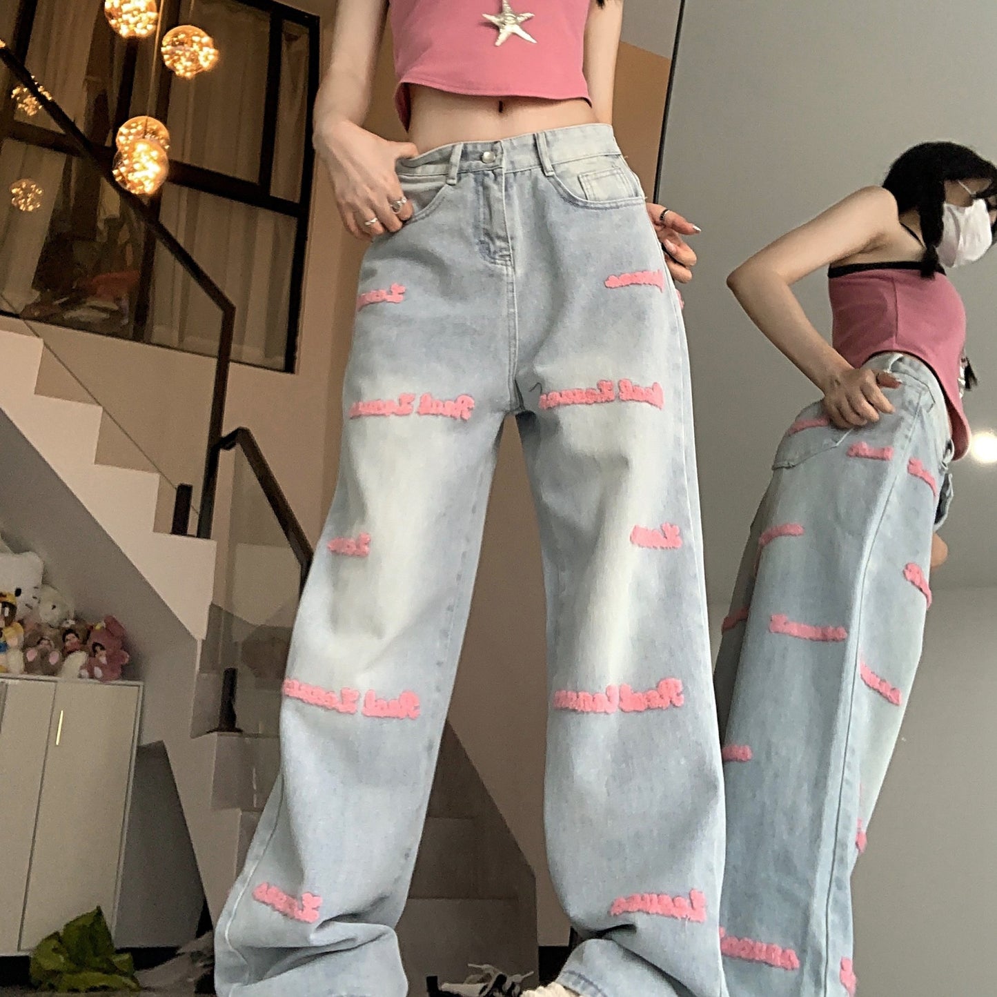 High-waisted embroidered denim jeans with straight-leg, button fly closure, and slight stretch.