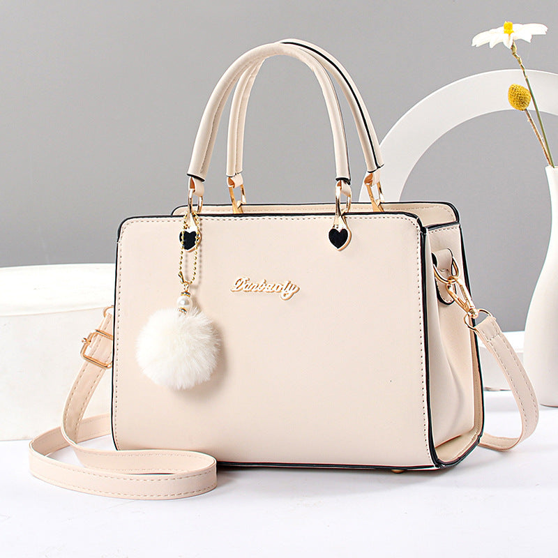 Women's stylish faux leather handbag with tassel embellishment, adjustable strap, zipper closure, and polyester lining. Available in multiple colors.