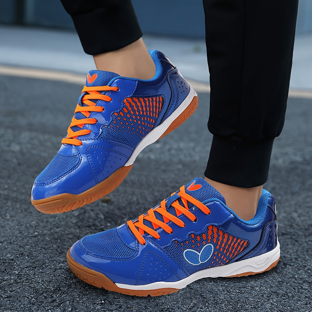 Breathable badminton and table tennis shoes in blue with orange accents, featuring a durable sole and lace-up design for all-season athletic wear.