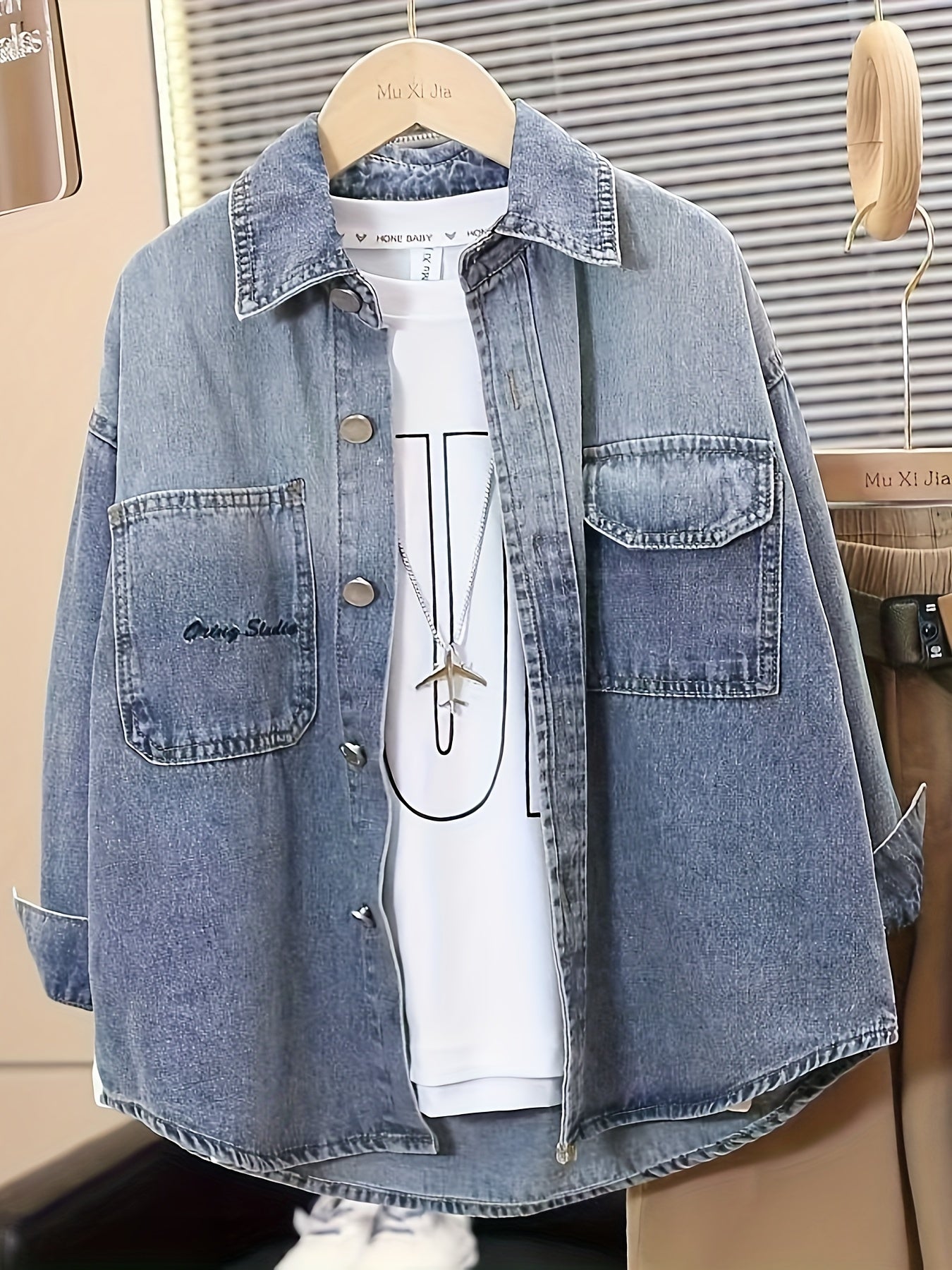 Boys' trendy denim jacket with loose fit, button-up front pockets and turn collar. Machine washable, perfect for fall/winter. Fashion-forward design with metallic buttons.