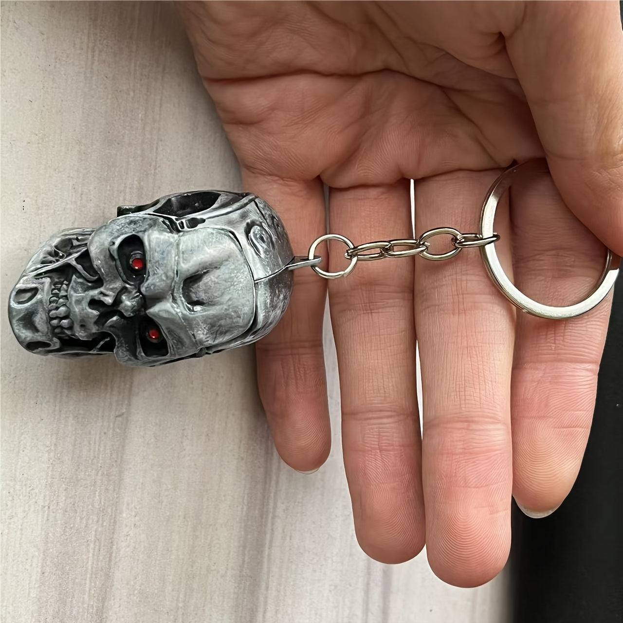 A stylish and versatile Terminator skull keychain that has a personality inspired by movies and TV shows. It is adorned with a golden pendant, adding an extra touch of flair.