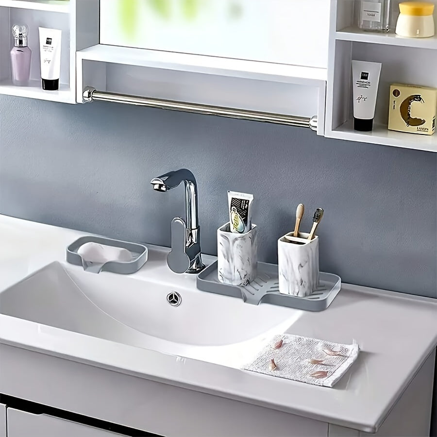 Silicone sink mat with soap dispenser, sponge drain, and countertop storage tray for drying and organizing bathroom accessories.