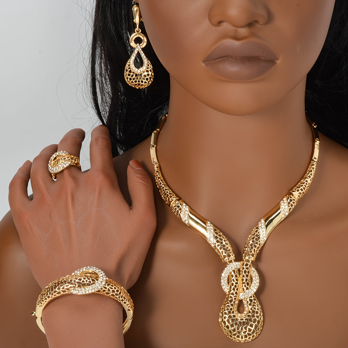 ZEADEAR presents a sophisticated gold-tone jewelry set featuring geometric cutouts. This luxurious collection includes a stunning Y-shaped necklace, bracelet, earrings, and ring, ideal for weddings and parties.