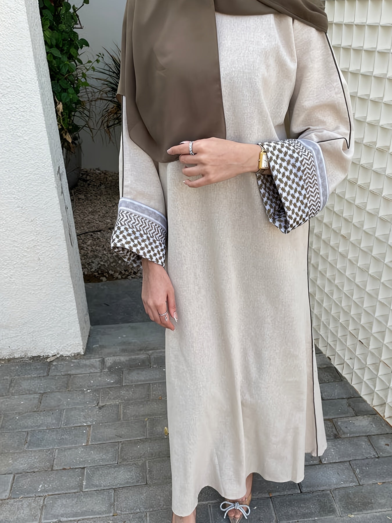 Stylish embroidered zippered abaya dress with long sleeves for Middle Eastern Muslim fashion. Made from polyester knit fabric, part of the spring/fall collection. Features a regular fit and