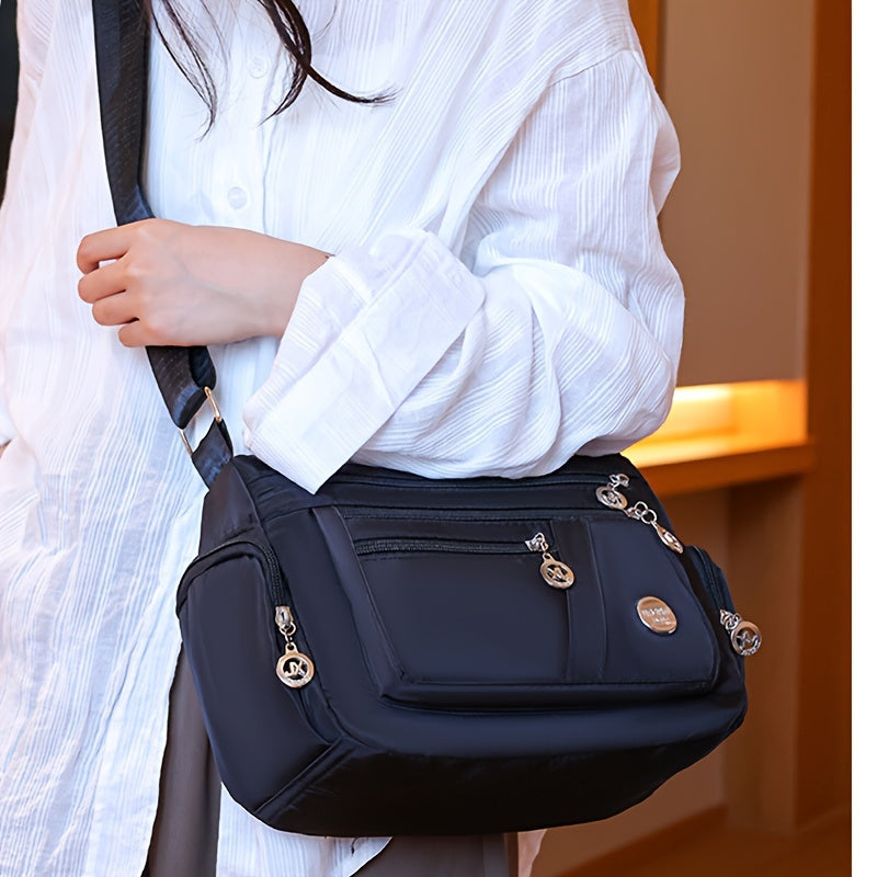 Stylish waterproof nylon crossbody bag with adjustable strap and multi-layer design, ideal for daily commute and travel.