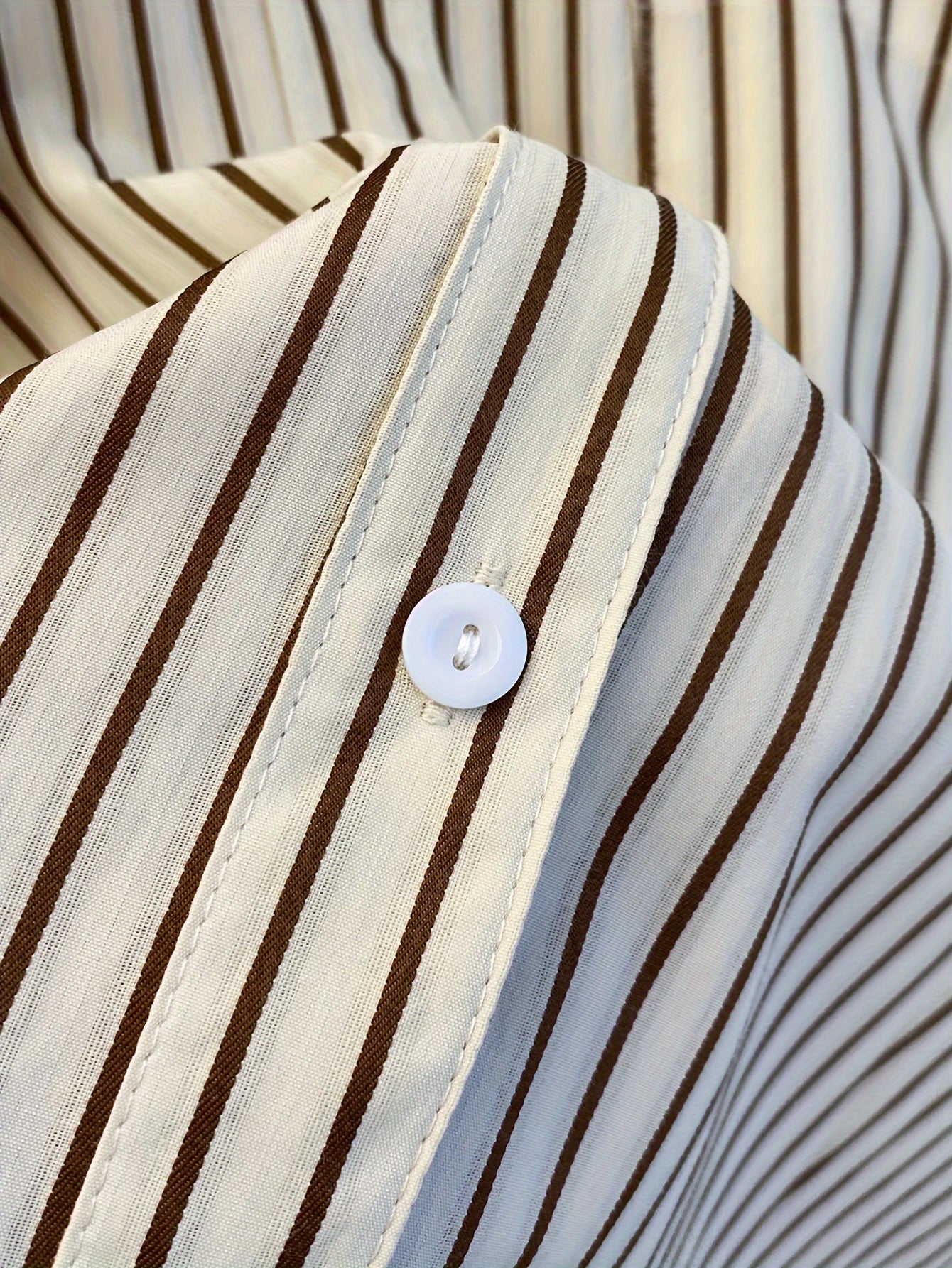 Striped blend shirt for women, with loose fit and ruffled hem detail. French-inspired chic look, perfect for casual wear.