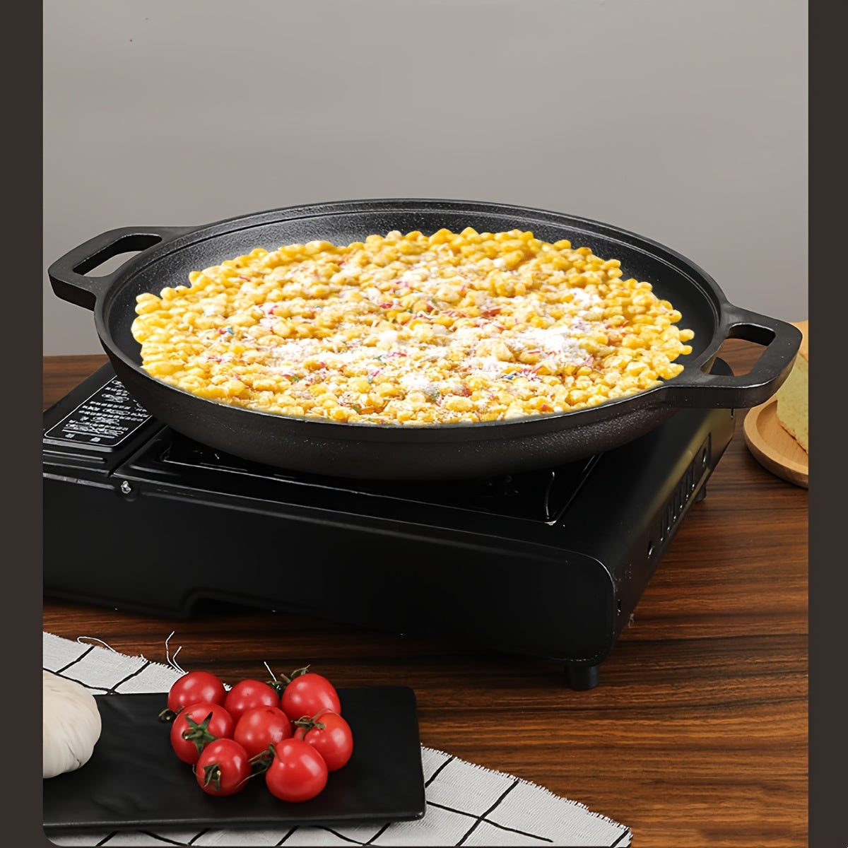 Double-handled non-stick frying pan for pancakes made of cast iron, meant for hand washing, with a durable uncoated surface ideal for cooking crepes and flatbreads.