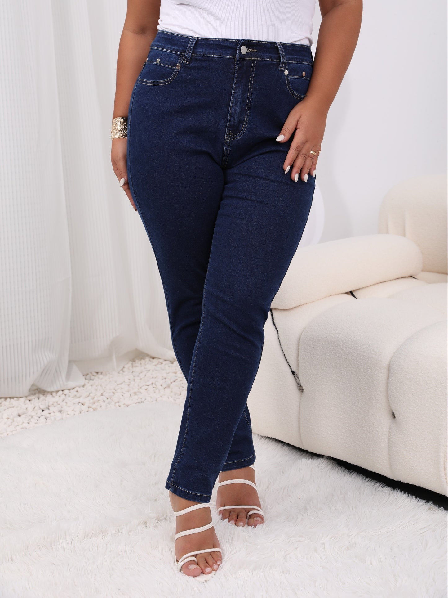 Women's plus size high-rise jeans with solid color and button fly, offering a comfortable stretch fit.