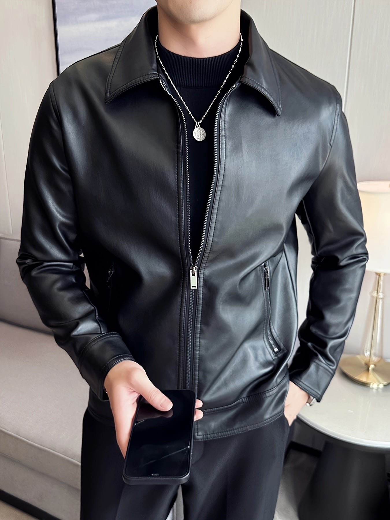 Men's black faux leather jacket with polyester lining, zippered lapel collar, solid color knit fabric, regular sleeve, and lightweight motorcycle style.