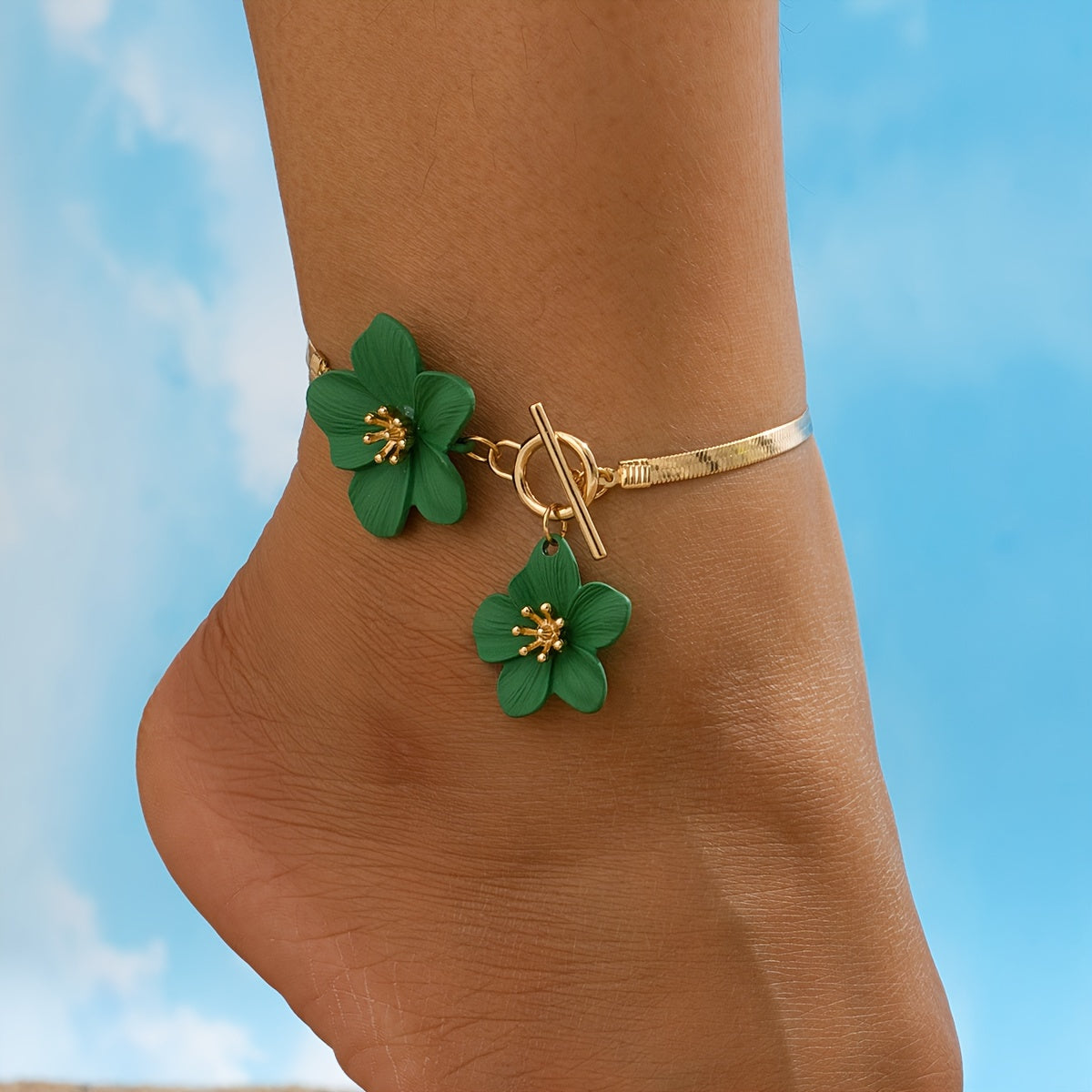 Stylish gold-tone anklet with white flower charms, perfect for vacations and everyday wear.