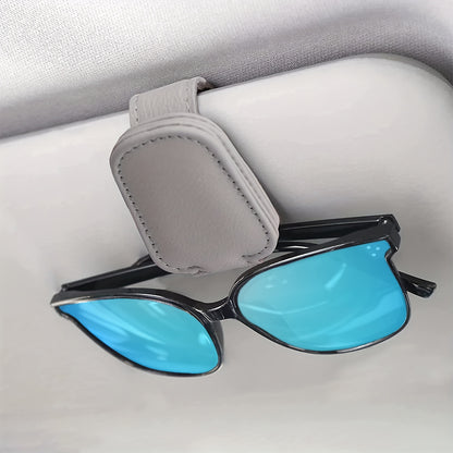 Stylish magnetic PU leather glasses holder for car visor with black textured grip. Compact design for easy access and secure storage.