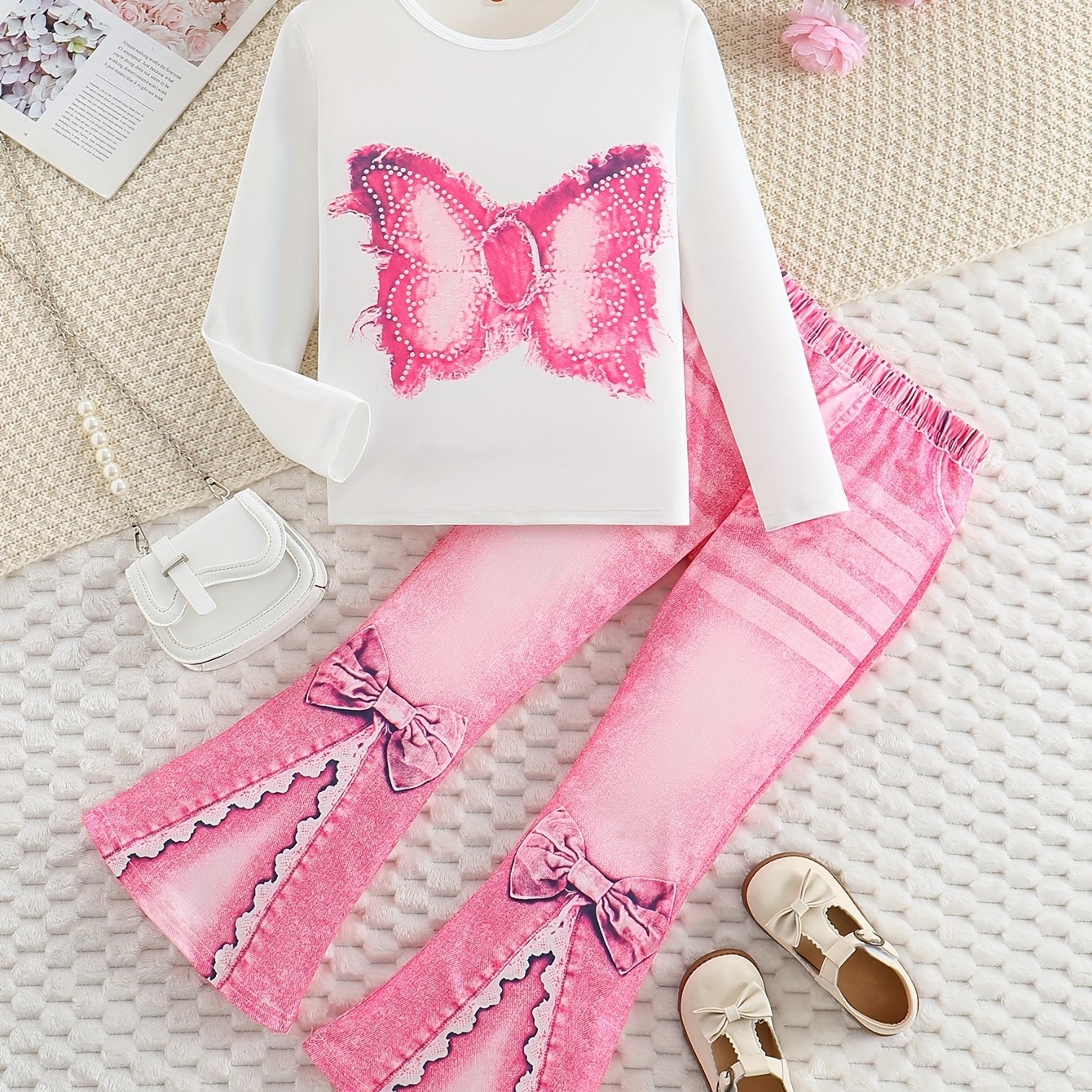 Girls' outfit set includes a long sleeve top with butterfly print and flared faux denim pants with a bow detail. Made of slight stretch knit fabric with an animal pattern, this regular fit